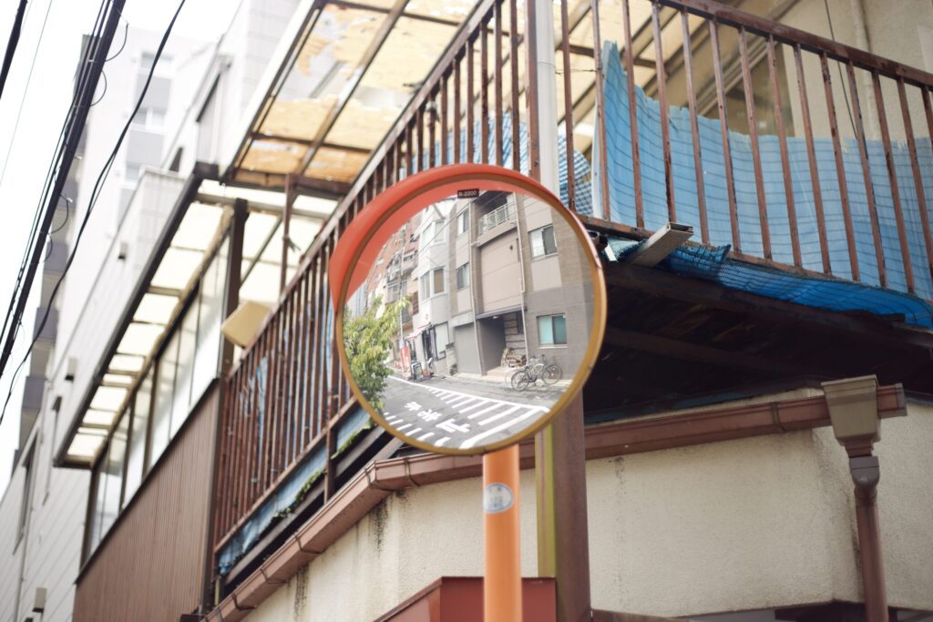 道路脇に設置されたカーブミラーを切り取った街歩きスナップ