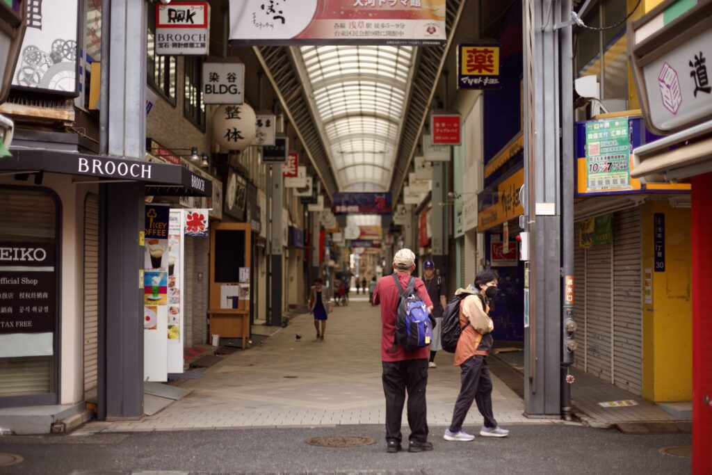 浅草の商店街の入口に立つ旅行者を撮影した東京スナップ写真